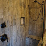 a shower area with wooden walls_